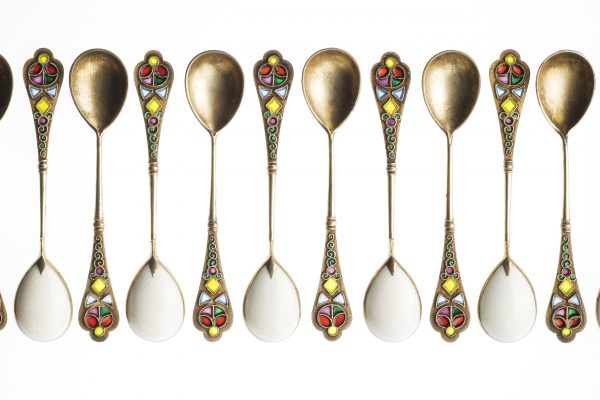 12 golden spoons lined up in a row