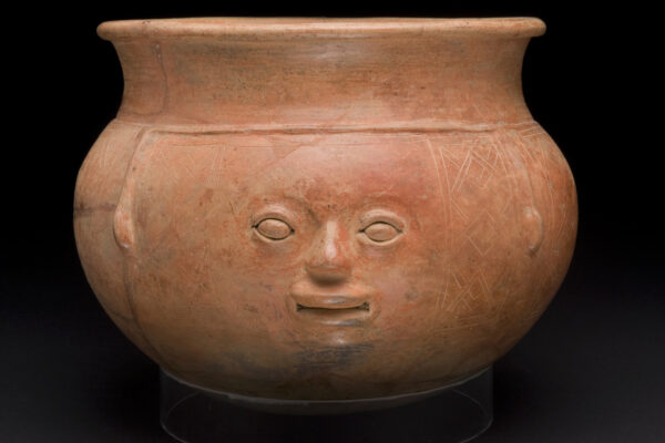 Terra cotta orangish-brown bowl with a human face sculpted on the front