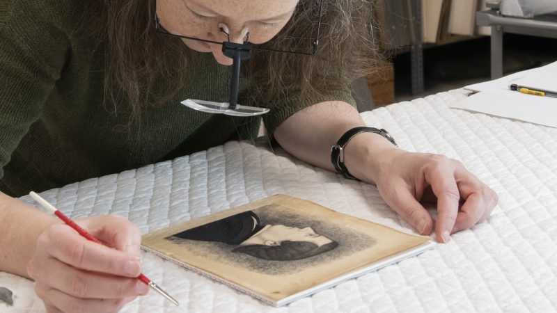 Woman examining a print on a table