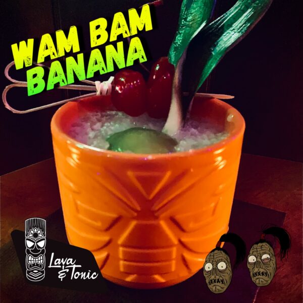 Cocktail in bright orange tiki head glass, with yellow text identifying it as WAM BAM Banana in the upper left and Lava and Tonic logo in the lower left