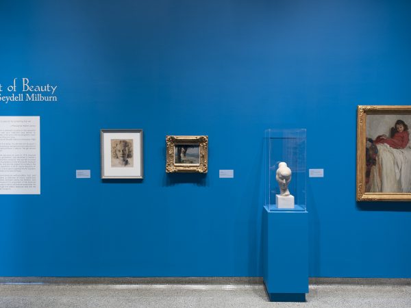 Interior view of galleries with paintings on the wall and a sculpture on a pedestal