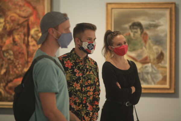 Interior view of visitors in the galleries wearing masks