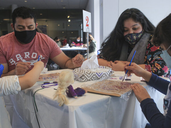 Family of four sitting at a able making art