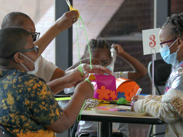 Four children around a table with artmaking supplies