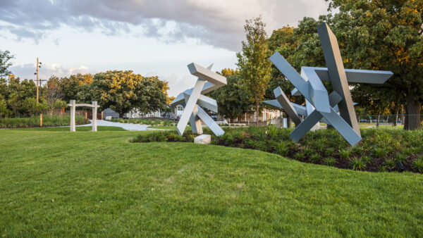 Photo of three sculptures in the Art Garden surrounded by green grass and plantings