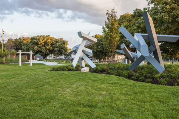 Photo of three sculptures in the Art Garden surrounded by green grass and plantings