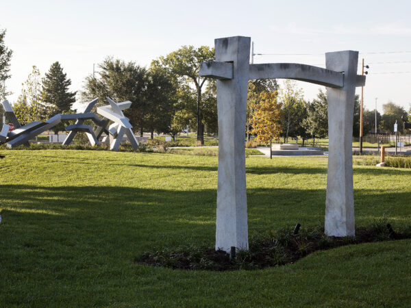 Exterior Art Garden with green grass, a walking path and a large marble sculpture in the foreground with steel sculptures in the background