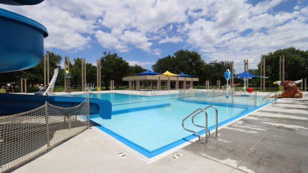 Photo of a pool with blue and yellow sunshades