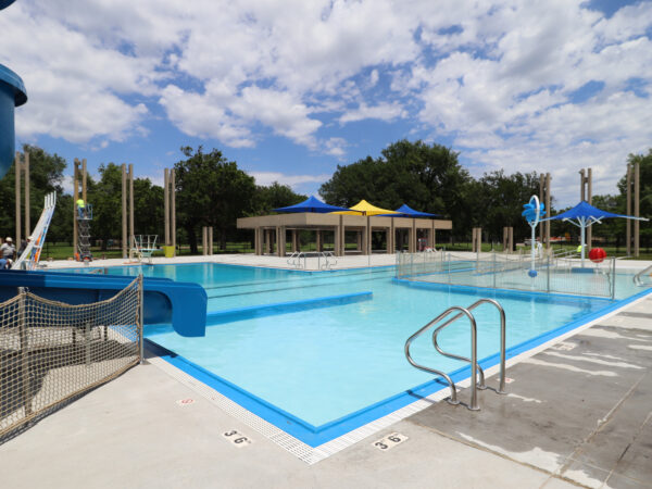 Photo of a pool with blue and yellow sunshades