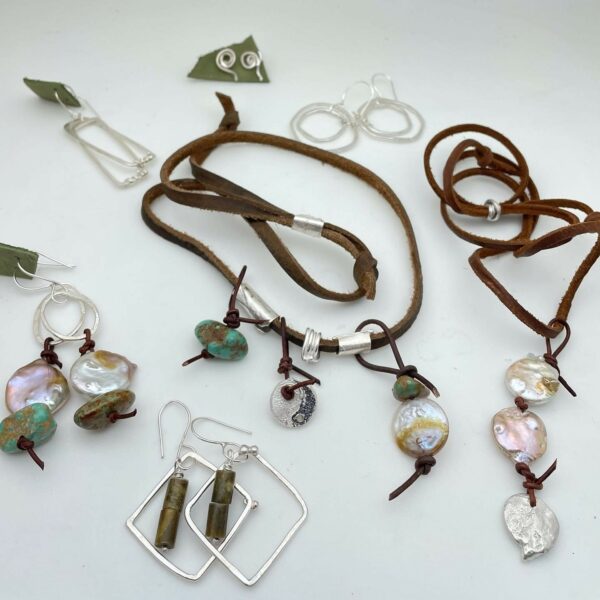 Assortment of jewelry featuring silver, stones and leather cord