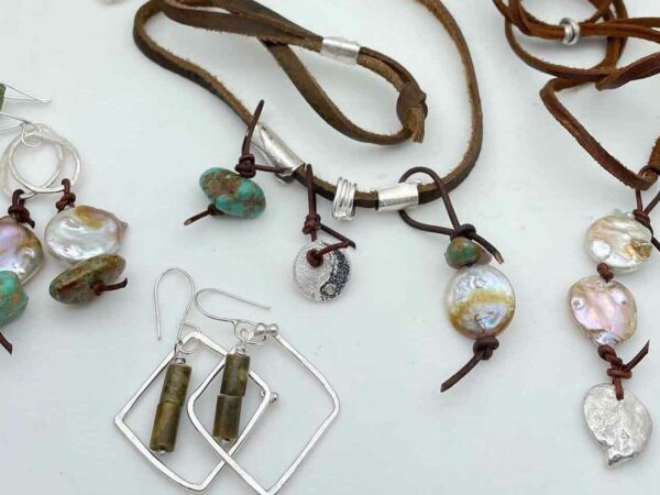 ssortment of jewelry featuring silver, stones and leather cords