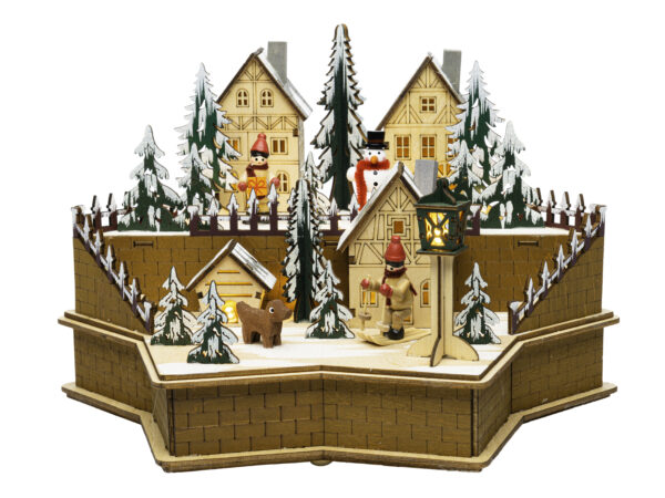 Old-fashed wooden village wutg red abd green accents, two levels of buildings surrounded by snow tipped evergreen trees