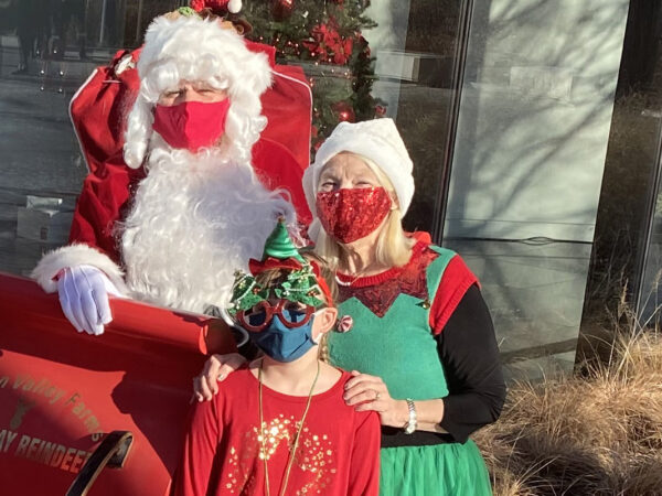 Santa, Mrs. Claus, dressed in green and red, and an elf dressed in red.