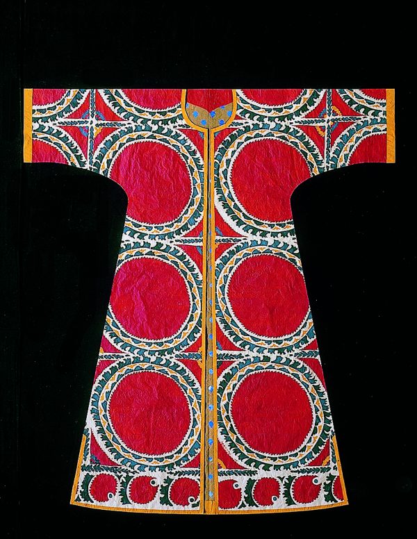 Photo of a kaftan made from paper that looks like real fabric. Large red circles surrounded by an orange, blue, and green print.