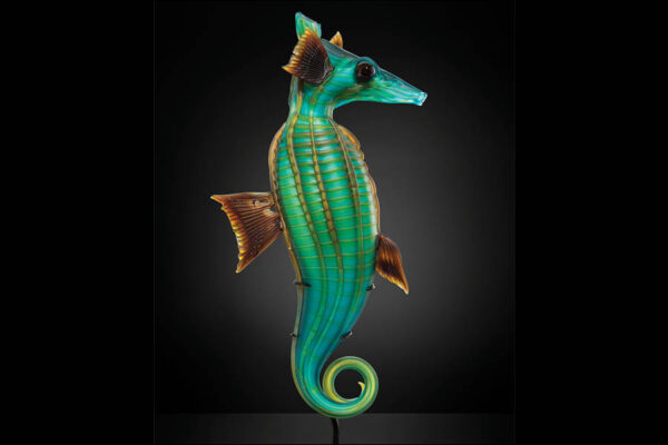 Glass sculpture of a seahorse, facing right, colors are green, blue, and brown