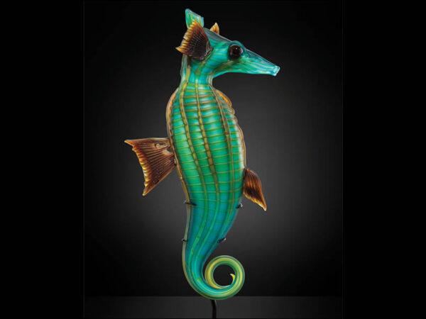 Glass sculpture of a seahorse, facing right, colors are green, blue, and brown