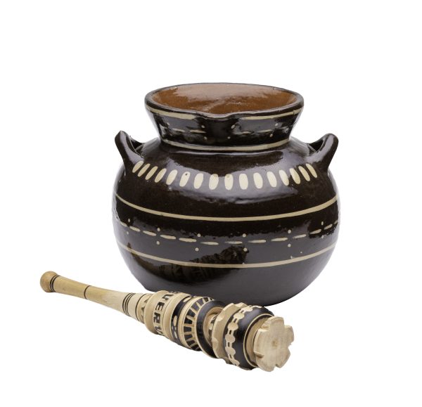 Brown pot with geometric design in white and tan and a carved wooded whisk with geometric designs with brown