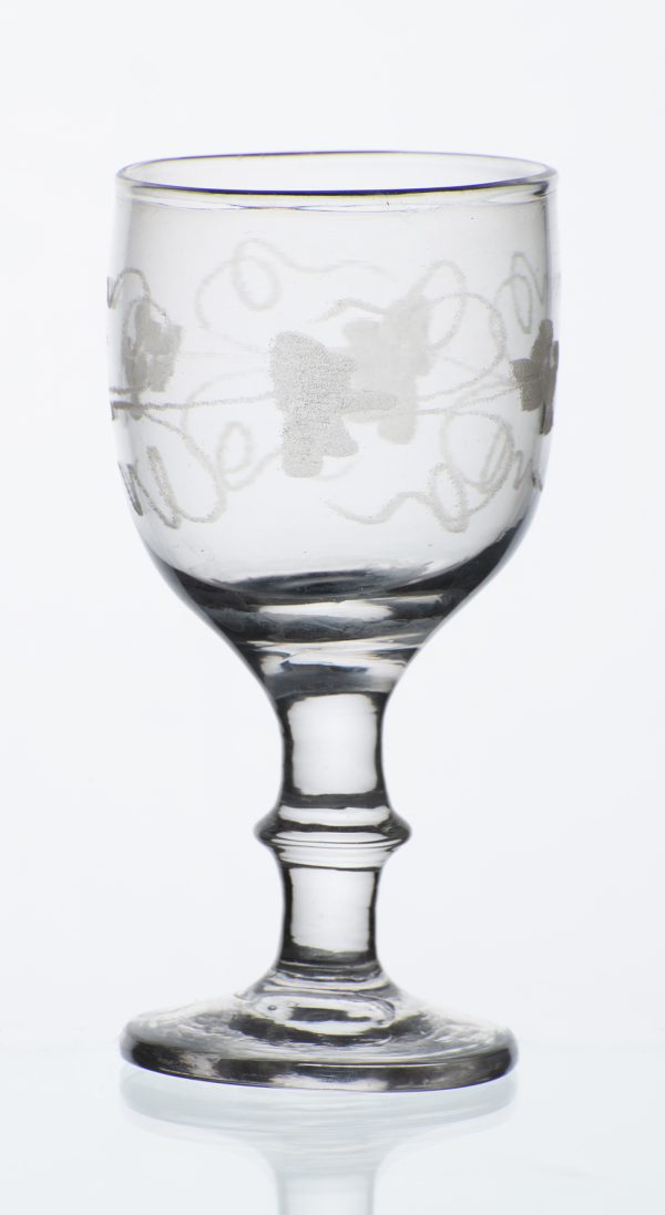 Clear glass cordial with acid etched grape vine pattern on bowl