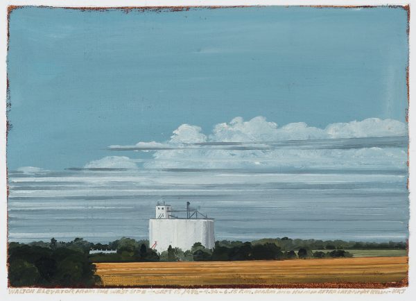 Plains skyline with low horizon with a white industrial building in dark green and yellow farm land. The sky is blue-gray with gray-white clouds.