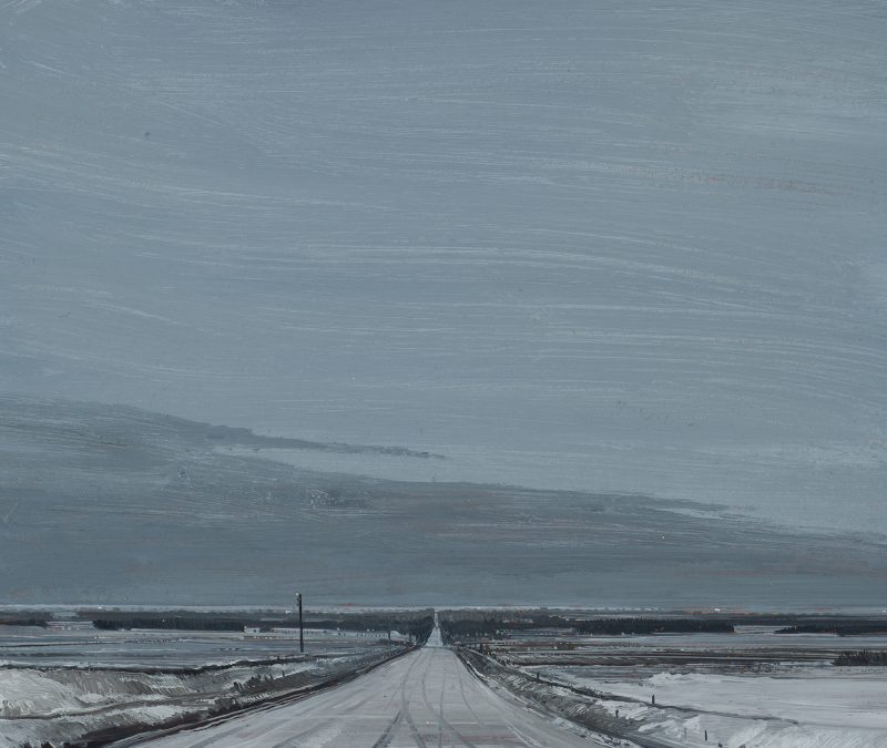 Gray streked plains skyline with snowy low horizon with road in center receding into distance.