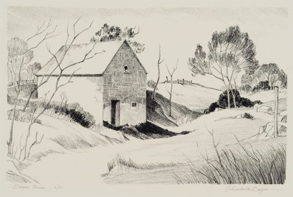 A stone barn stands along a path surrounded by sparse trees and brush. A wooden fence can be seen just behind the barn in the distance hills.