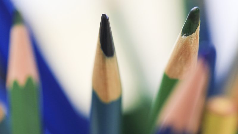 Photo of several colored pencils with tips up