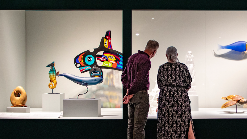 Photograph of an older couple admiring the Clearly Indigenous Exhibit