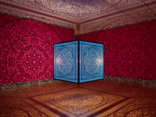 alt= Anila Quayyum Agha, 'All the Flowers are For Me (Turquoise)', 2017. Lacquered laser-cut steel, halogen bulb, 60 × 60 × 60 inches. Wichita Art Museum, Museum purchase, American Art Acquisition Fund established by friends and franchisees of Pizza Hut Inc., in honor of Dan and Frank Carney