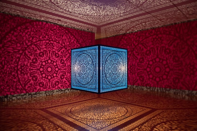 alt= Anila Quayyum Agha, 'All the Flowers are For Me (Turquoise)', 2017. Lacquered laser-cut steel, halogen bulb, 60 × 60 × 60 inches. Wichita Art Museum, Museum purchase, American Art Acquisition Fund established by friends and franchisees of Pizza Hut Inc., in honor of Dan and Frank Carney